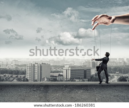 business man puppet walks on the concrete parapet