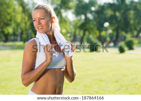 young attractive woman with a white towel around his neck, resting after sport exercises