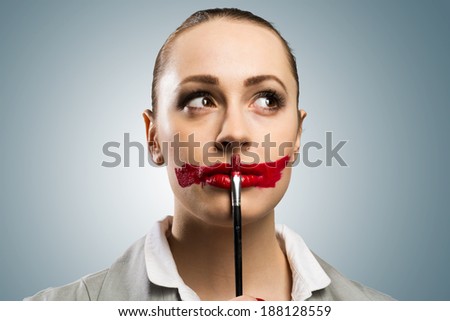 Conceptual image of a young woman with vivid red mouth
