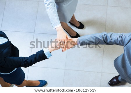 team of three businessmen clasped her hands together, a symbol of teamwork