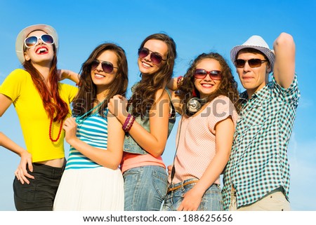 group of young people wearing sunglasses and hats hugging and standing in a row, spending time with friends