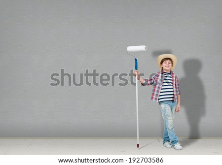image of a boy with hat standing near the blank wall