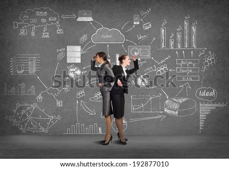 two business women holding hands, looking in different directions, teamwork