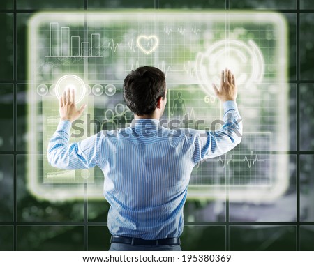 businessman working with modern virtual technologies, stands back, hands touching the screen
