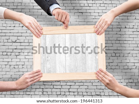 Close up of human hands holding wooden frame