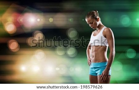 Sport woman in shorts and top exercising at stadium