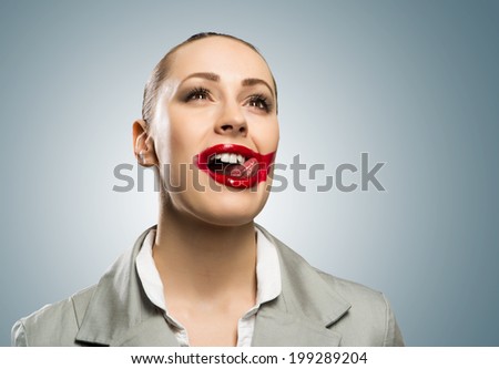 young woman with vivid red mouth, smiling and licking mouth