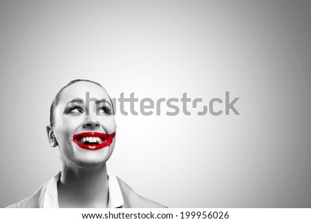 Conceptual black and white image of a young woman with vivid red mouth