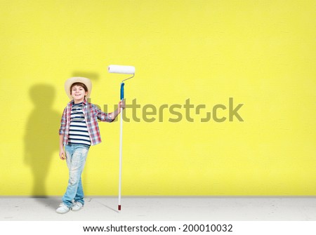 image of a boy with hat standing near the painted wall