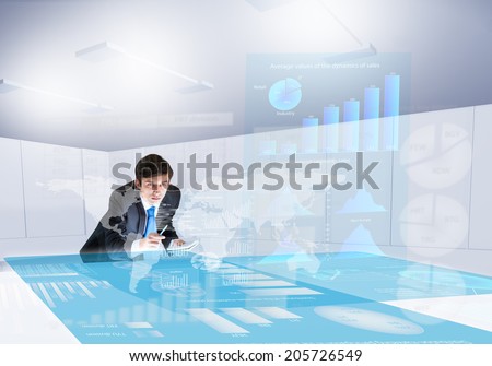 Young businessman looking at digital screen with market data