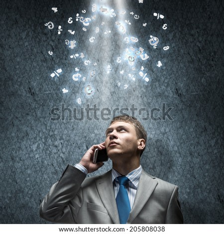 Young disappointed businessman talking on mobile phone with tears in eyes