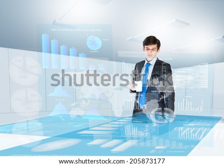 Young businesswoman looking at digital screen with market data