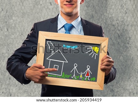 Close up of businessman holding chalkboard with family sketches