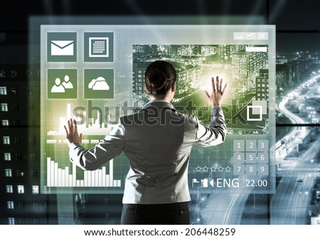 Rear view of businesswoman touching icon of media screen