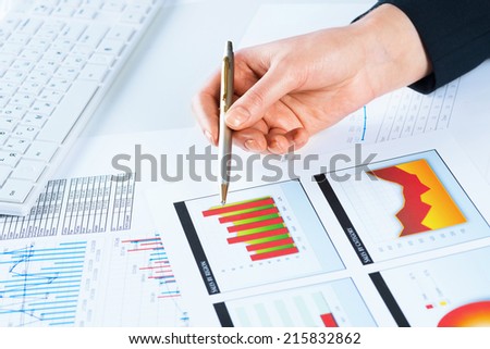 image of a female hand pointing to the financial growth charts