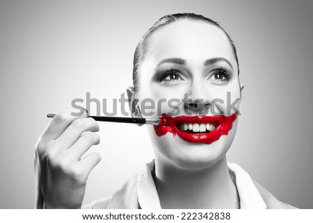 Conceptual black and white image of a young woman with vivid red mouth