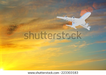 Airplane flying high in sky in beams of sunset