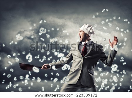 Handsome businessman wearing cook hat with pan in hands