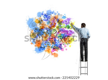 Back view of businessman standing on ladder and drawing on wall