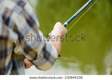 Close up of man sitting on pier with rod