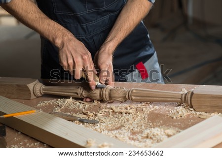 Close up carpenter\'s hands that work with cutter
