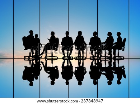 Silhouettes of group of business people against sunset
