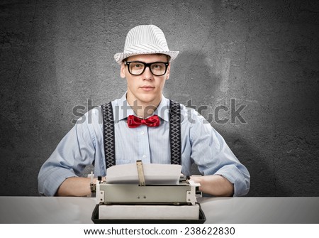 Young man writer with typing machine waiting for inspiration