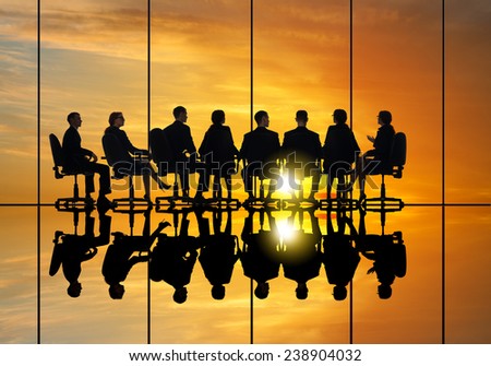 Silhouettes of group of business people against sunset