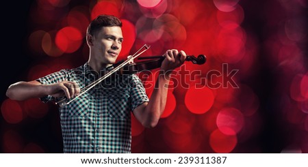 Young handsome guy in shirt playing violin