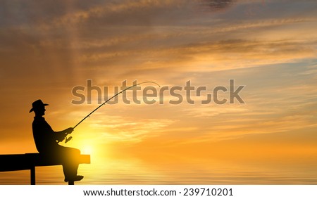 Silhouette of man sitting at bridge and fishing