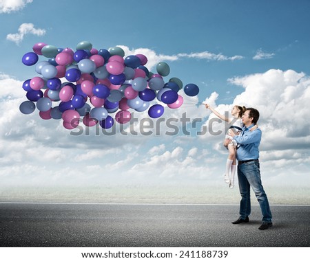 Happy father and daughter outdoor with bunch of balloons