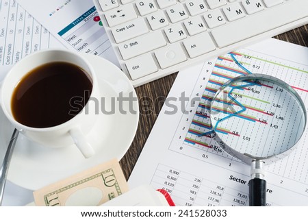 Close up of keyboard documents and coffee on office table