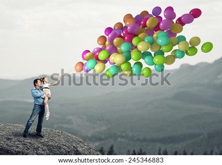 Happy father and daughter outdoor with bunch of balloons