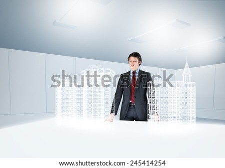 Young businessman and digital model of construction project