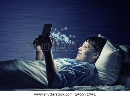 Young teenager guy in bed using tablet pc