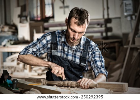 Young craftsman in uniform working at carpentry