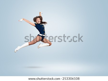 Young beautiful smiling cheerleader girl jumping high