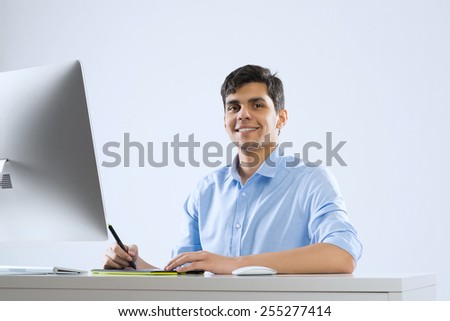Young graphic designer sitting at desk and working