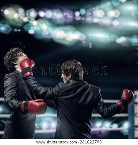 Two businessman with boxing gloves in the ring fighting with each other