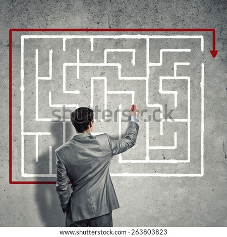 business man draws a maze on the wall, the concept of finding a solution in business
