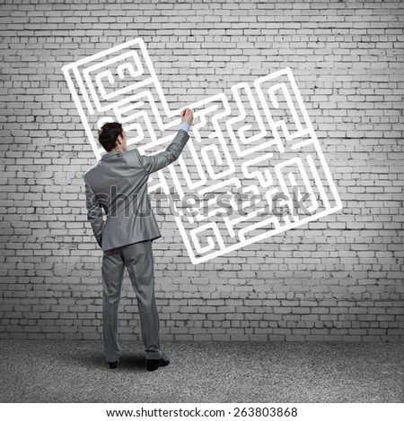 business man draws a maze on the wall, the concept of finding a solution in business