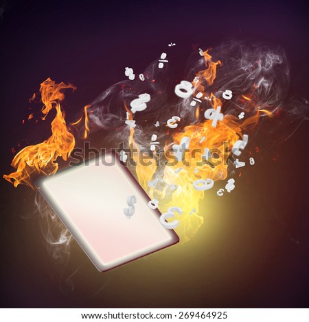 Close up of tablet computer burning in fire flames