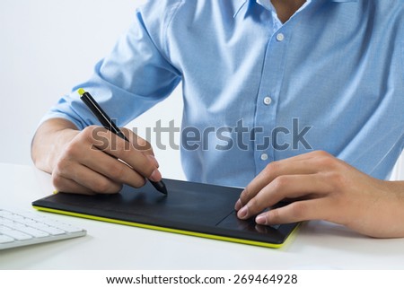 Young graphic designer sitting at desk and working
