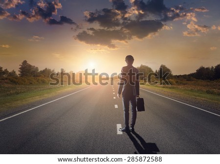 Businessman goes straight on his way on asphalt road