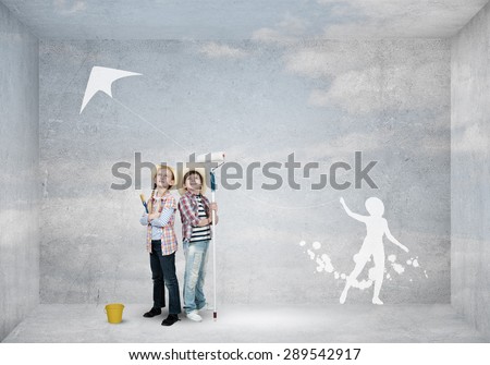 Cute boy and girl of school age painting wall with roller