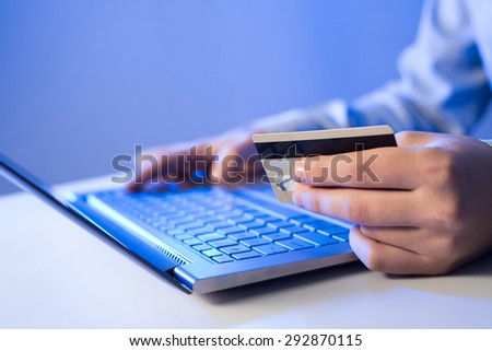 Close up of man using credit card to pay online