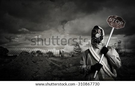 Stalker in gas mask with precaution stop signboard