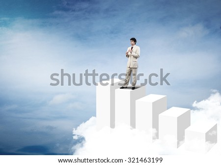 Cheerful businessman standing on graph bars and playing fife