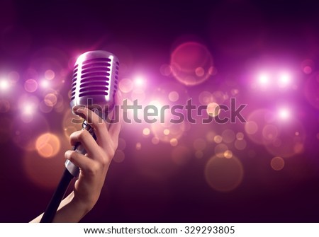 Close up of female hand on blurred background holding microphone
