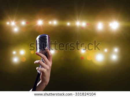 Close up of female hand on blurred background holding microphone